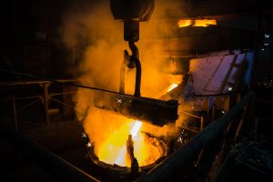 Molten steel pouring. Liquid hot metal of steel spills out of the ladle at steel factory
