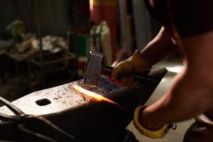 Blacksmith shaping heated metal bar